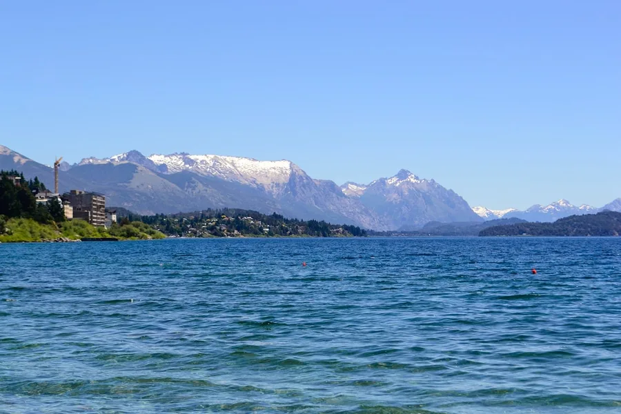 Bariloche em 5 dias: Roteiro dia a dia com foco nos pontos menos explorados 4 Lago sereno com montanhas nevadas ao fundo em Bariloche, Patagônia.