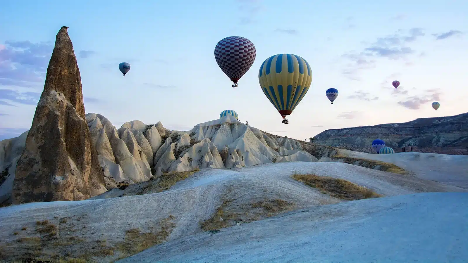Balões de ar quente sobre as chaminés de fada de Göreme, na Capadócia, ao nascer do sol