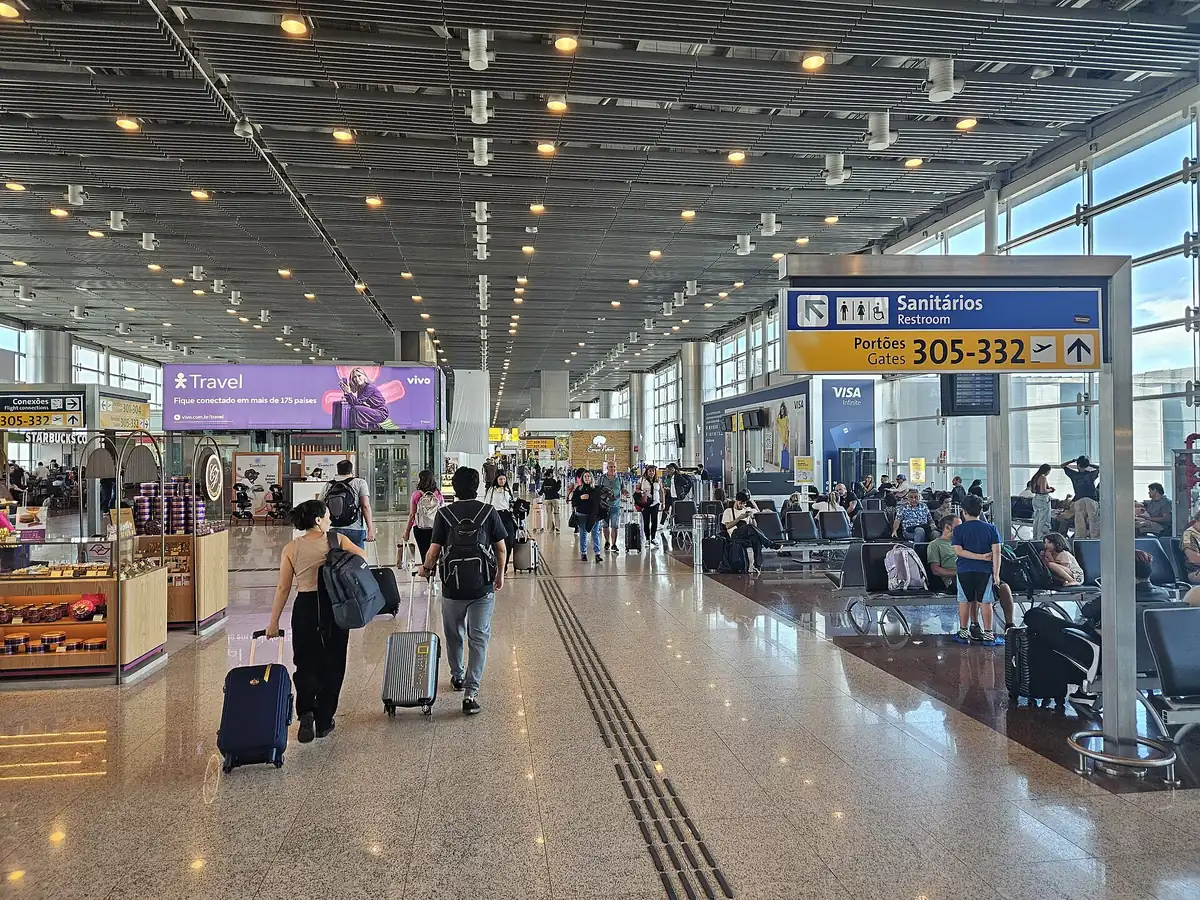 Passageiros com malas de rodinha caminham pelo saguão de embarque do Terminal 3 do aeroporto de Guarulhos, em São Paulo